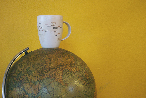 a mug sitting upon a planet floating in yellow space 